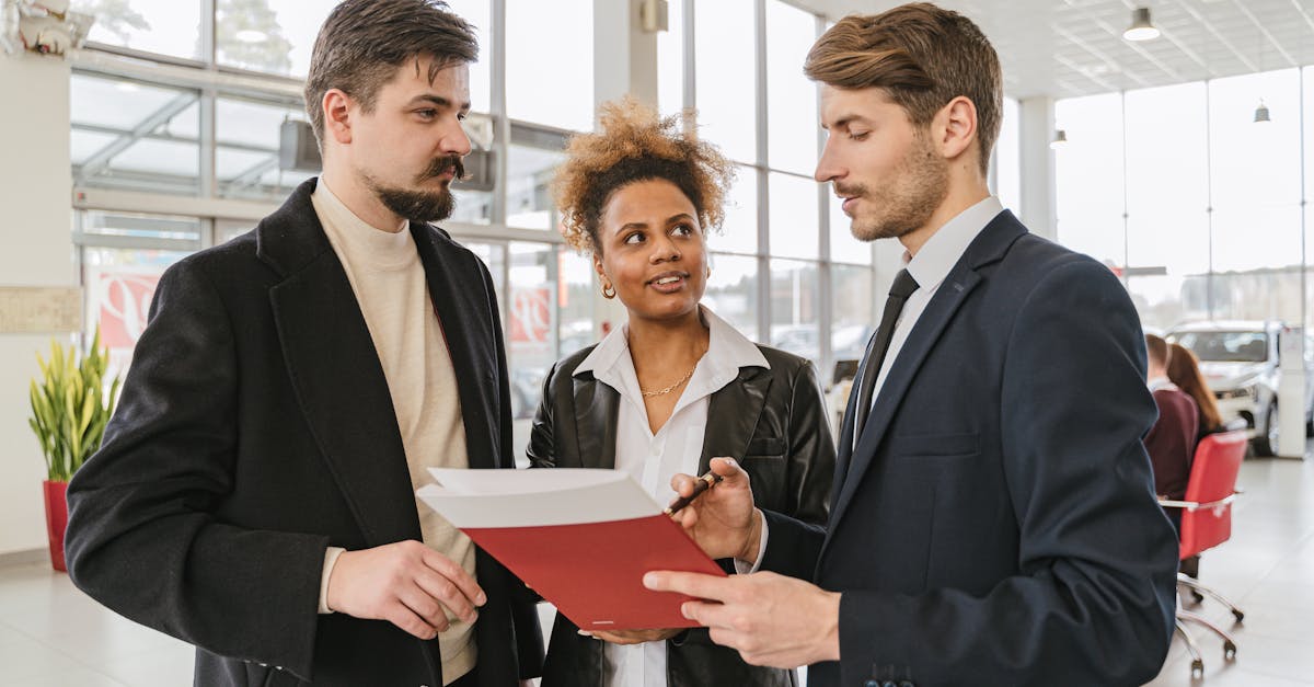 Business professionals discussing a car lease or purchase agreement in a showroom setting.